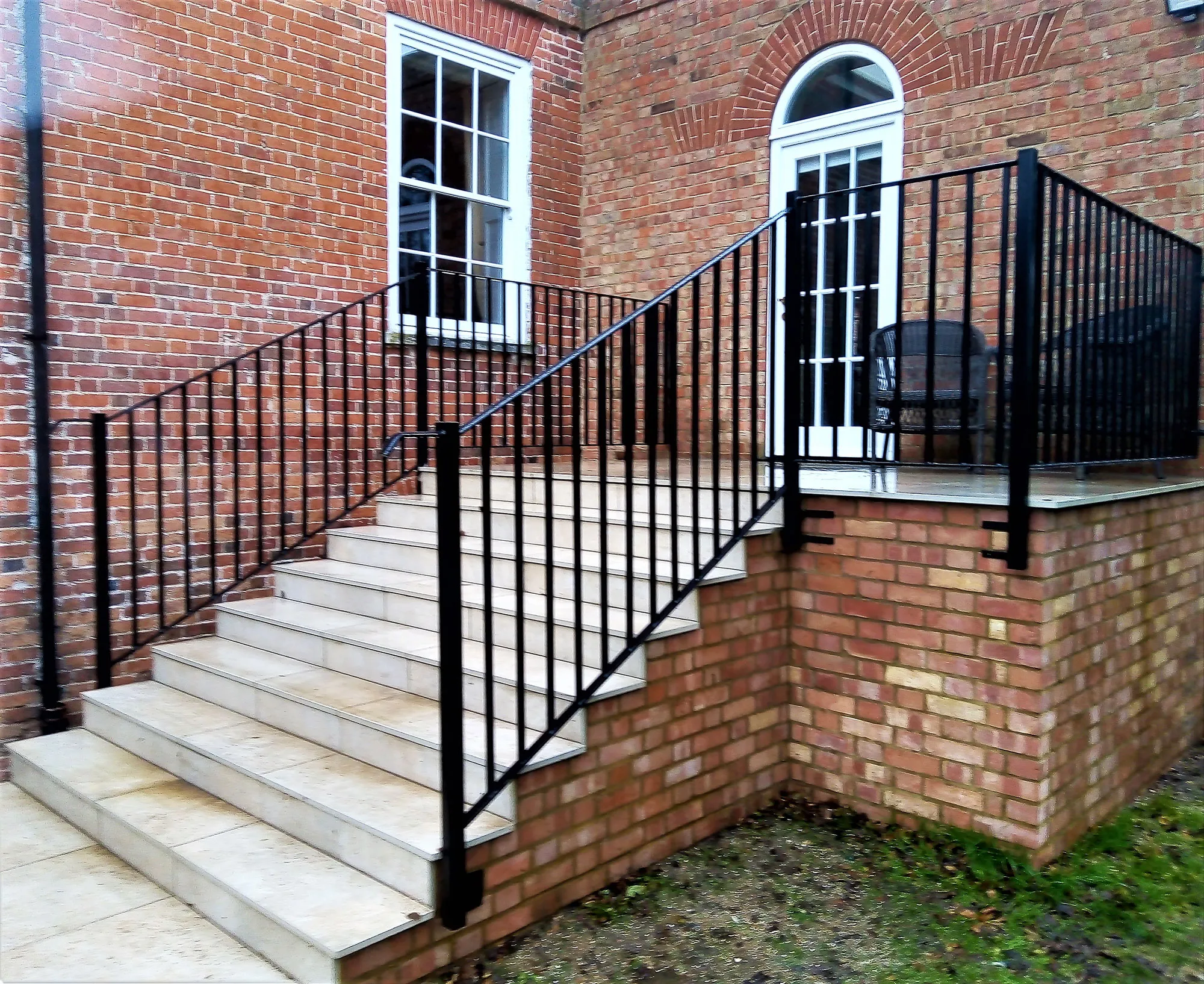 A brick building with a black iron railing.