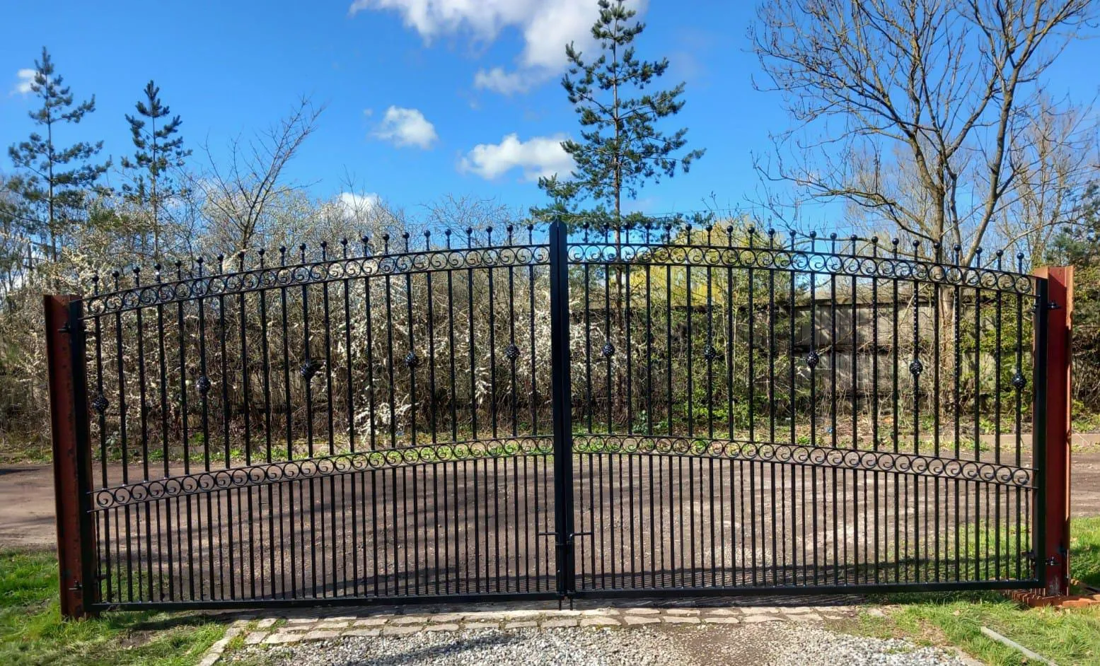 A gated driveway with a stone walkway leading to it.