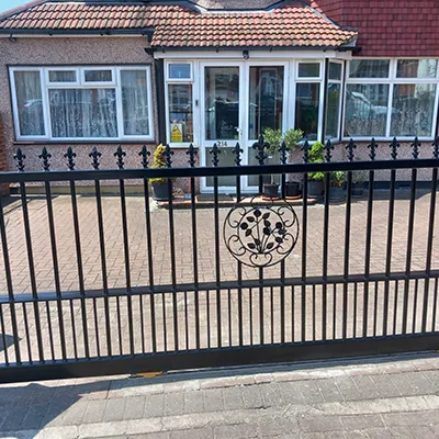 a black gate with a house in the background