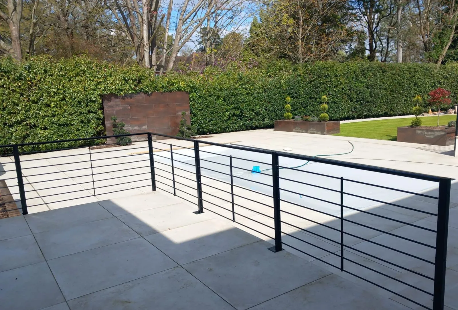 A fenced in swimming pool surrounded by trees.