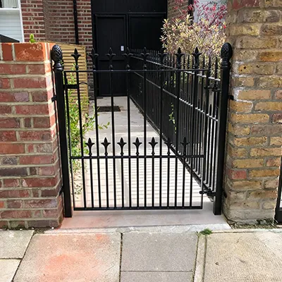 a black gate is open on a brick building