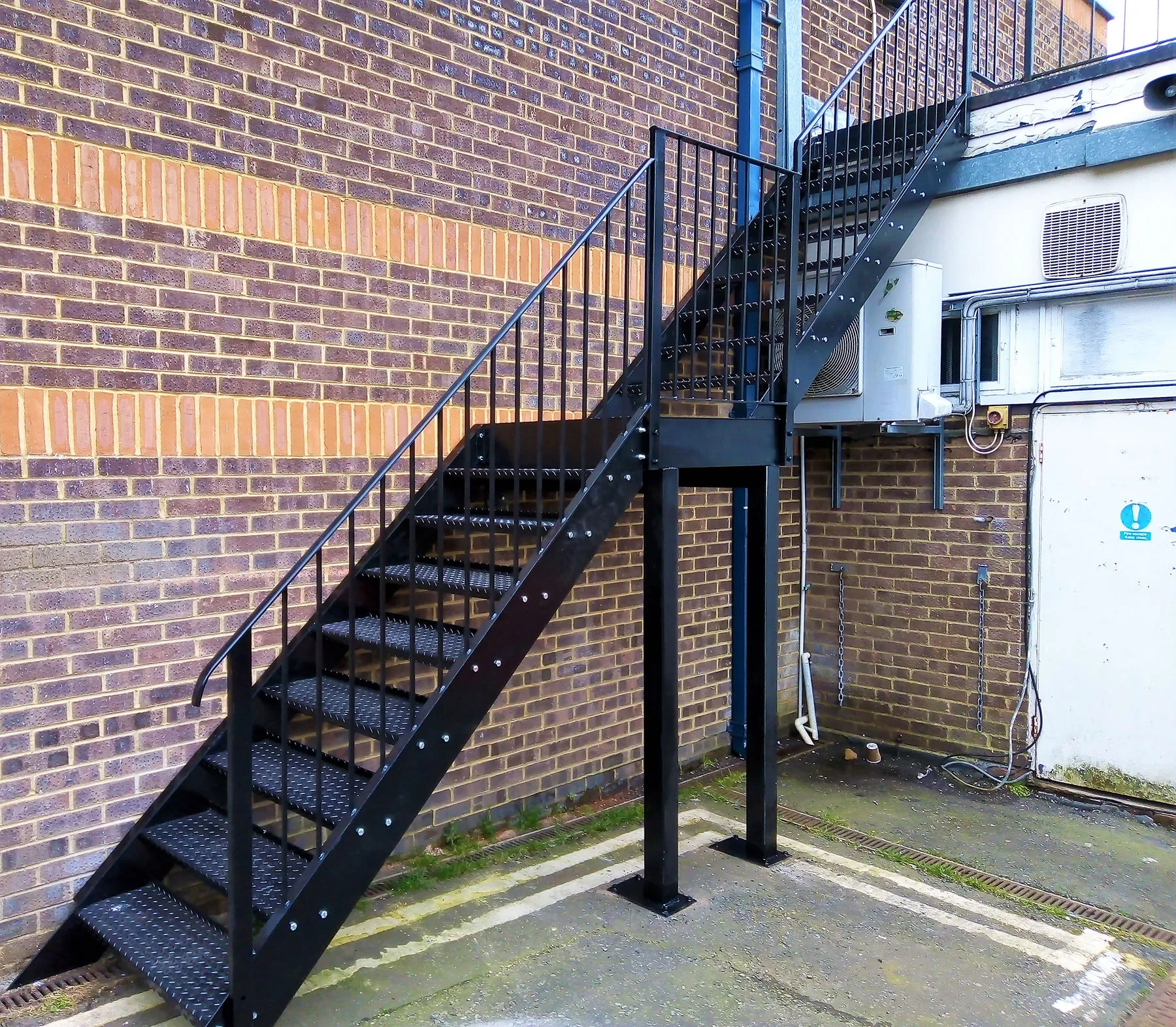 A set of stairs next to a brick wall.