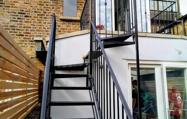 A man walking down a set of stairs next to a building.